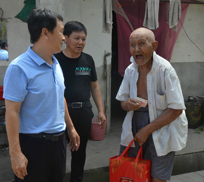 图一  潘敬秋（左一）在箭场岗村走访慰问退伍军人凃辉先（右一）.JPG